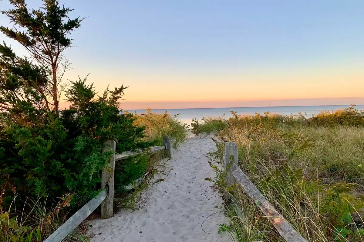 A sand path cut through beach grass opening onto the open Atlantic on Cape Cod's outer shore