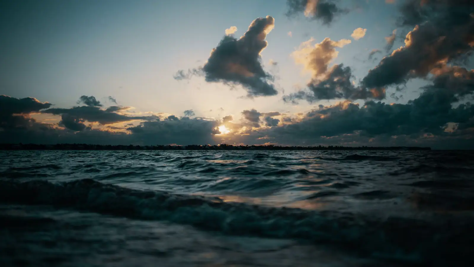 Late light and low cloud over moving water near a narrow channel