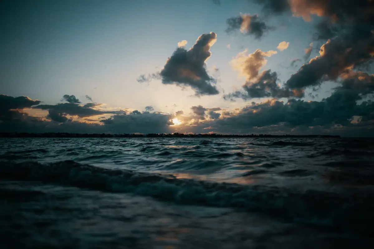 Late light and low cloud over moving water near a narrow channel