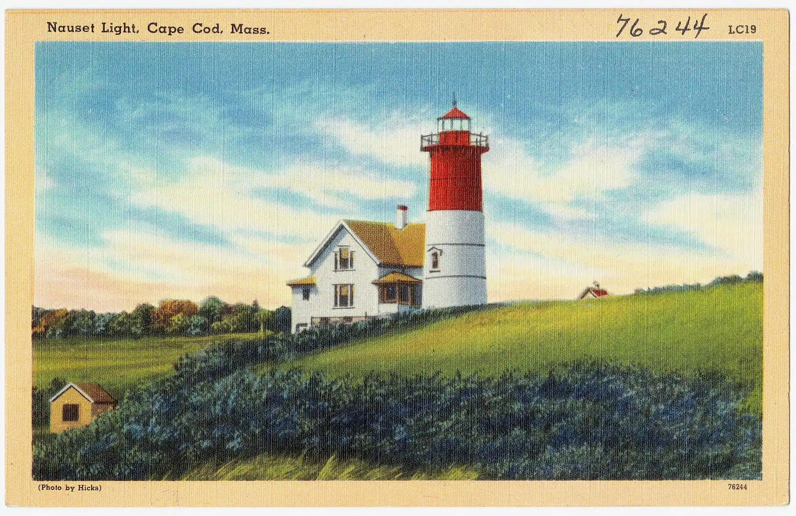 The red and white tower of Nauset Light standing above low trees in Eastham, Massachusetts