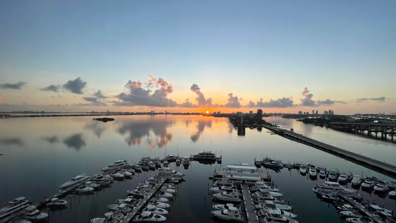 Rows of boats moored in a marina basin on flat water at first light