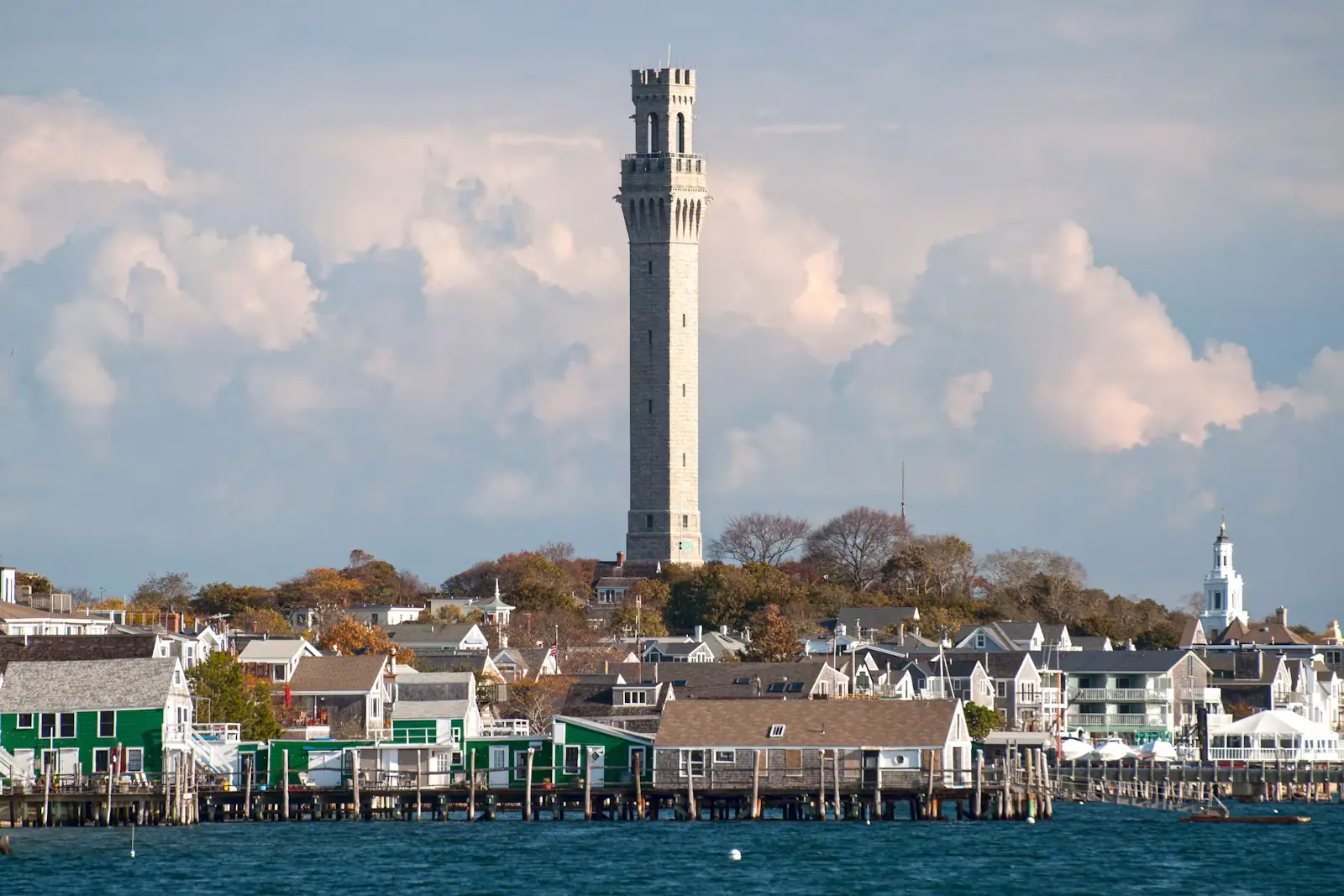 The granite tower of the Pilgrim Monument rising above Provincetown's rooftops beside the harbour