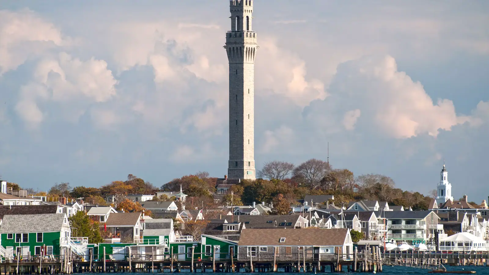 The granite tower of the Pilgrim Monument rising above Provincetown's rooftops beside the harbour